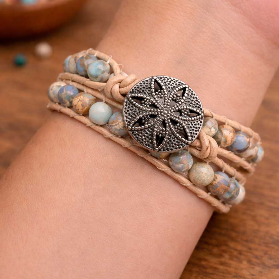 Close-up of a handmade Sea Sediment Jasper wrap bracelet worn on the wrist